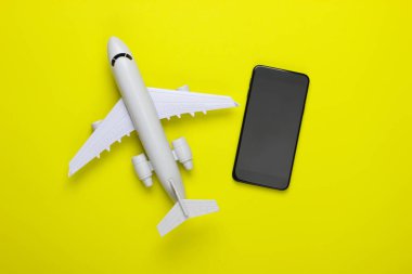 Akıllı telefondan uçak bileti rezervasyonu. Seyahat konsepti. Tıbbi uçak, yeşil arka planda akıllı telefon. Üst Manzara. Minimalizm