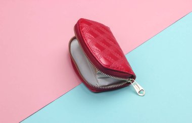 Üzerinde pembe mavi pastel arka planda fermuar olan kırmızı, açık bir cüzdan. Moda minimalizmi