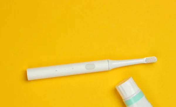 Moderne Elektrische Zahnbürste Und Zahnpasta Auf Gelbem Hintergrund Zahnpflegekonzept Ansicht — Stockfoto