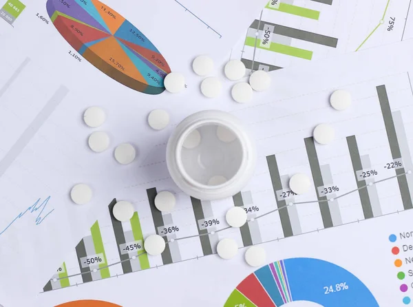 Medical statistics and analytics. Bottle of pills with graphs and charts.