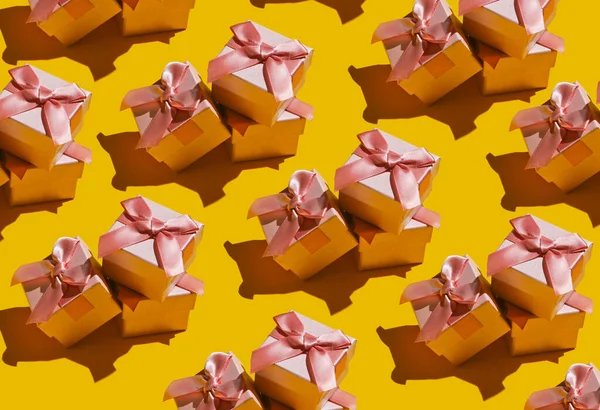 Pop art background. A lot of gift boxes with a bow on yellow background. Holiday concept, birthday. Fashion shot with shadow