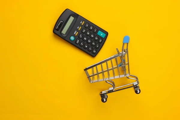 Shopping Vagn Med Miniräknare Gul Bakgrund Ekonomisk Beräkning Shopping Inköpskostnader — Stockfoto