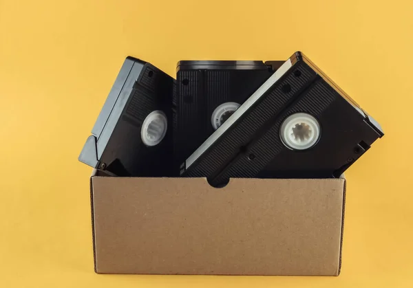 Pudełko Tekturowe Kasetami Wideo Żółtym Tle — Zdjęcie stockowe