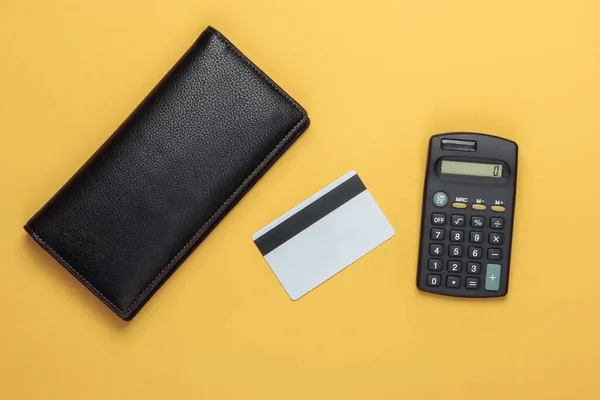 家庭预算的计算 费用的计算 钱包和银行卡 黄底计算器 顶部视图 — 图库照片