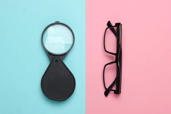 Förstoringsglas Och Glasögon Blå Rosa Pastell Bakgrund Ovanifrån — Stockfoto