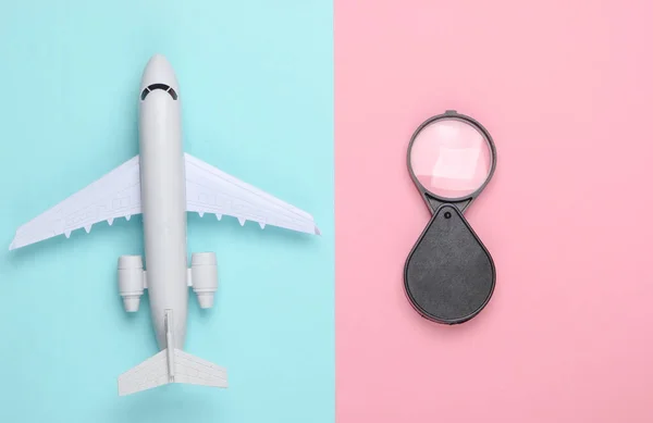 Plochá Cestovní Kompozice Figurka Letadla Lupa Růžovém Modrém Pastelovém Pozadí — Stock fotografie