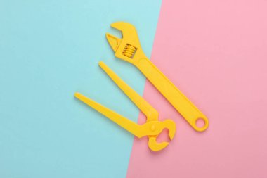 Sarı oyuncak plastik anahtar ve pembe mavi pastel arka planda maşa. Üst görünüm