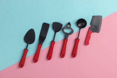 Pembe-mavi pastel arka planda oyuncak mutfak aletleri. Üst görünüm