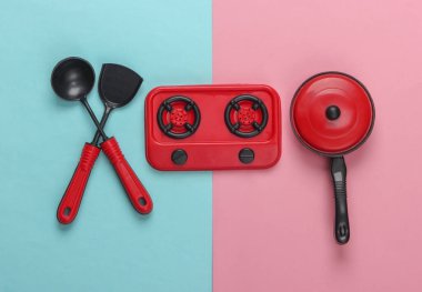 Pembe mavi pastel arka planda çocuk mutfağı. Esrar, mutfak aletleri, soba. Üst görünüm
