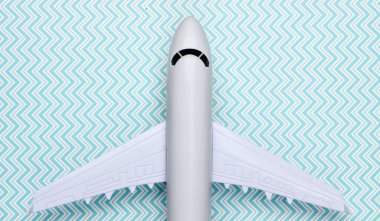 Mavi pastel arka planda uçağın oyuncak modeli. Turizm, hava yolculuğu, minimalizm. Üst görünüm