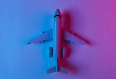 Neon mavi-pembe ışıklı bir uçak figürü. Üst görünüm