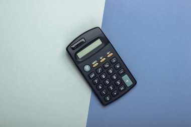 Mor mavi arka planda siyah hesap makinesi. Üst görünüm