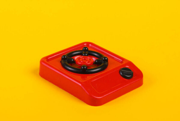 Toy plastic stove on a yellow background. Kid's Kitchen