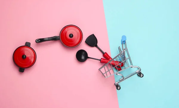 Miniatuur Winkelwagentje Met Keukengereedschap Pannen Een Blauw Roze Pastelachtergrond Bovenaanzicht — Stockfoto