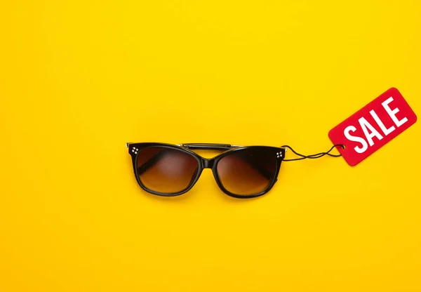 Modne Okulary Przeciwsłoneczne Czerwoną Etykietą Sprzedaży Żółtym Tle Widok Góry — Zdjęcie stockowe
