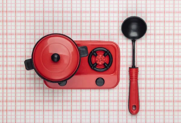 带锅子的玩具塑料炉灶 勺放在桌布上 孩子的厨房 高瞻远瞩 简约主义 — 图库照片