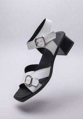 Women's leather sandal floating on white background