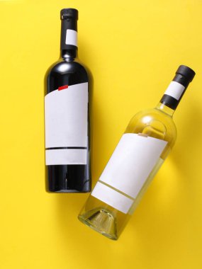 Red and white wine bottles with white blank labels on yellow background