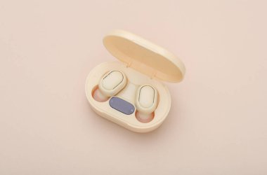Wireless Earphones with Charging Case on Beige Background