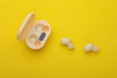 Wireless Earphones with Charging Case on yellow Background