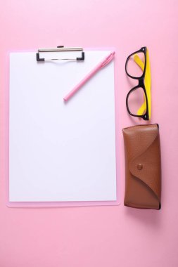 Pembe arka planda gözlüklü deri çanta. Düz yatıyordu