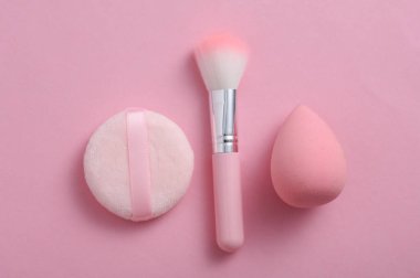 Makeup sponges and brush on a pink background