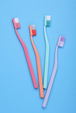 Set of plastic toothbrushes on a blue background