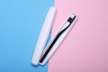 Plastic toothbrush with case on blue pink background