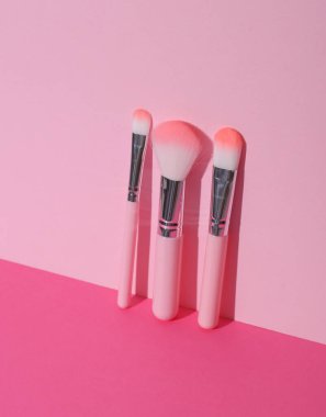 Makeup brushes on pink background. Creative layout. Beauty concept
