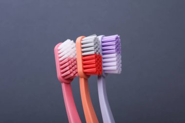 Many Plastic toothbrushes on dark gray background