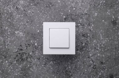 Koyu gri beton duvarda ışık düğmesi