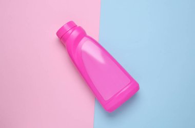 Mavi pembe arka planda bir şişe çamaşır jölesi