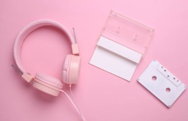Pembe arka planda 80 'lerin ses kaseti ve stereo kulaklık. Üst görünüm