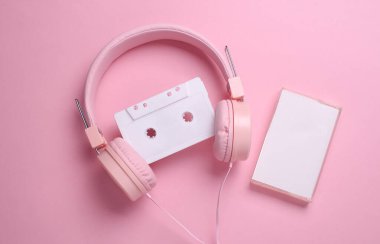 Pembe arka planda 80 'lerin ses kaseti ve stereo kulaklık. Üst görünüm