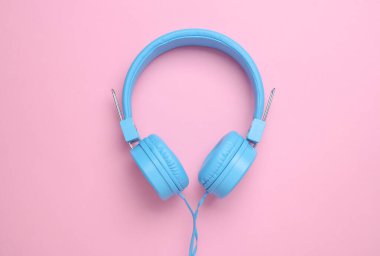 Pembe arka planda mavi stereo kulaklık.