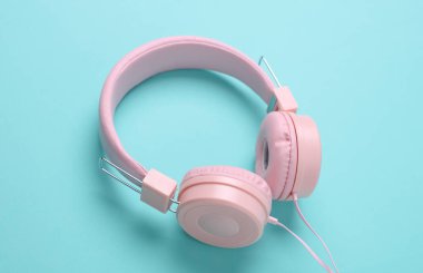 Mavi arka planda pembe stereo kulaklıklar.