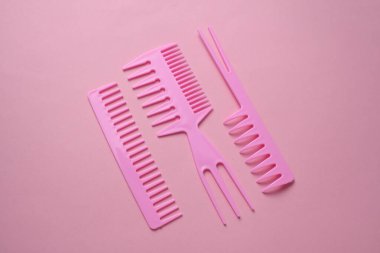 Pembe arkaplanda plastik taraklar.