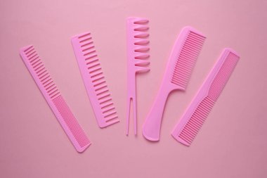 Pembe arkaplanda plastik taraklar.