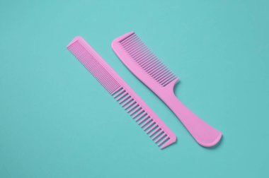 Nane yeşili arkaplanda pembe plastik taraklar.