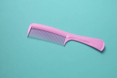 Nane yeşili arkaplanda pembe plastik tarak.