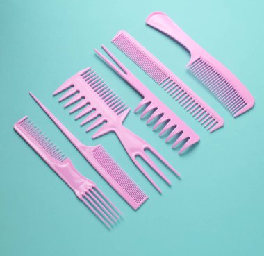 Nane yeşili arkaplanda pembe plastik taraklar.