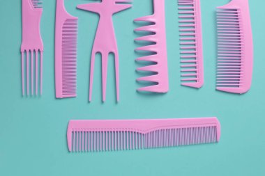 Nane yeşili arkaplanda pembe plastik taraklar.