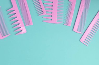 Nane yeşili arkaplanda pembe plastik taraklar.