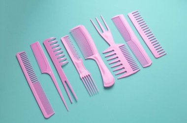 Nane yeşili arkaplanda pembe plastik taraklar.