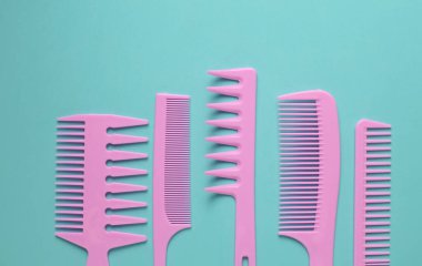 Nane yeşili arkaplanda pembe plastik taraklar.