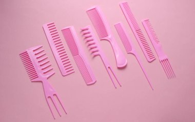 Pembe arkaplanda plastik taraklar.