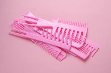 Pembe arkaplanda plastik taraklar.