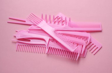 Pembe arkaplanda plastik taraklar.