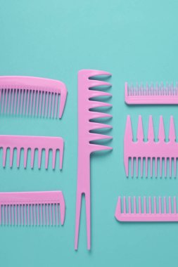 Nane yeşili arkaplanda pembe plastik taraklar.