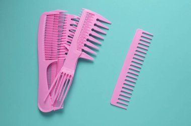 Nane yeşili arkaplanda pembe plastik taraklar.